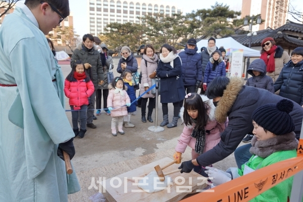 ▲ 한 가족이 운현궁에서 '떡매치기' 체험을 하고 있다. ⓒ 서울시