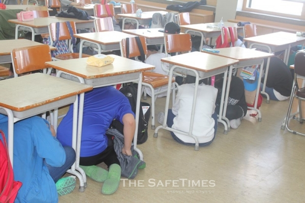 ▲ 경기 토평초에서 개최한 지진훈련에서 어린이들이 책상 밑으로 대피하고 있다.