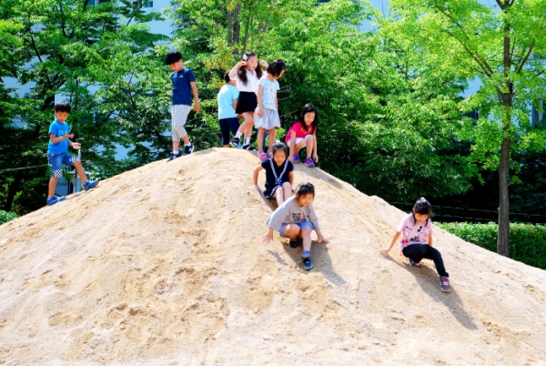 ▲ '꿈을 담은 놀이터'에 조성된 모래언덕인 '바람의 언덕'에서 어린이들이 뛰어놀고 있다. ⓒ 서울시 교육청