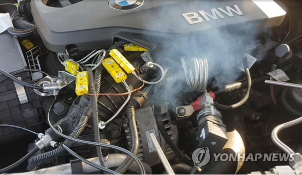 ▲ 한국교통안전공단이 7일 공개한 BMW 화재원인 시험 과정 모습. 흡기계통의 천공부로부터 배출가스가 발산되고 있다.