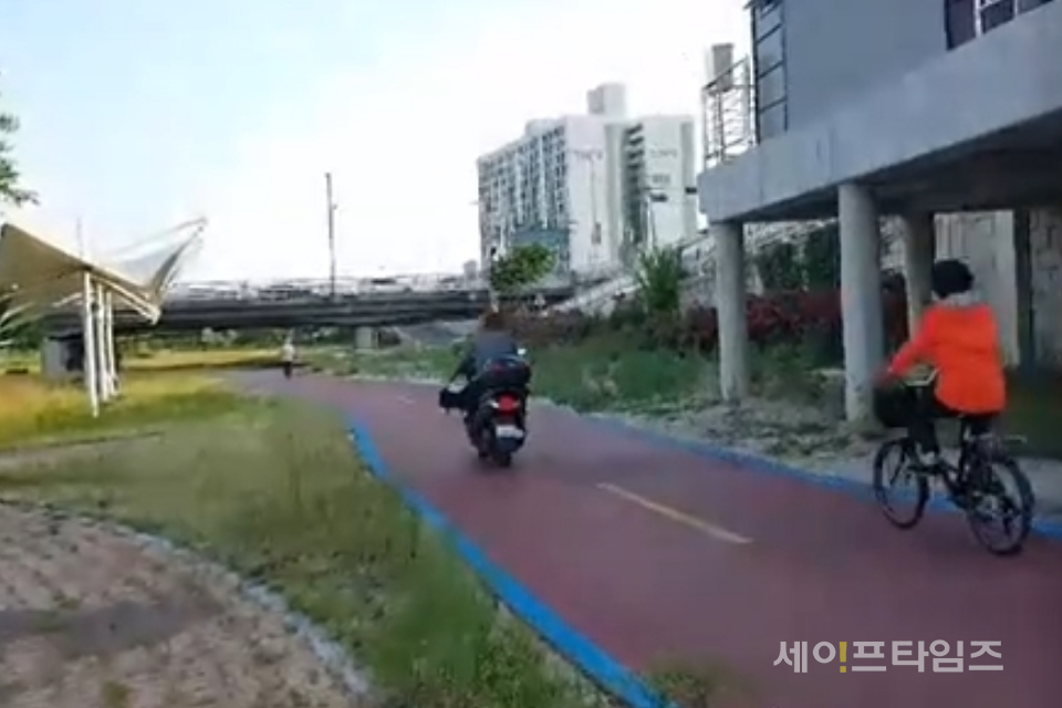 ▲ 대전 유성구 갑천변 자전거 전용도로에 오토바이를 탄 남성이 자전거를 타고 가는 한 여성을 앞지르고 있다. ⓒ 남철우 기자