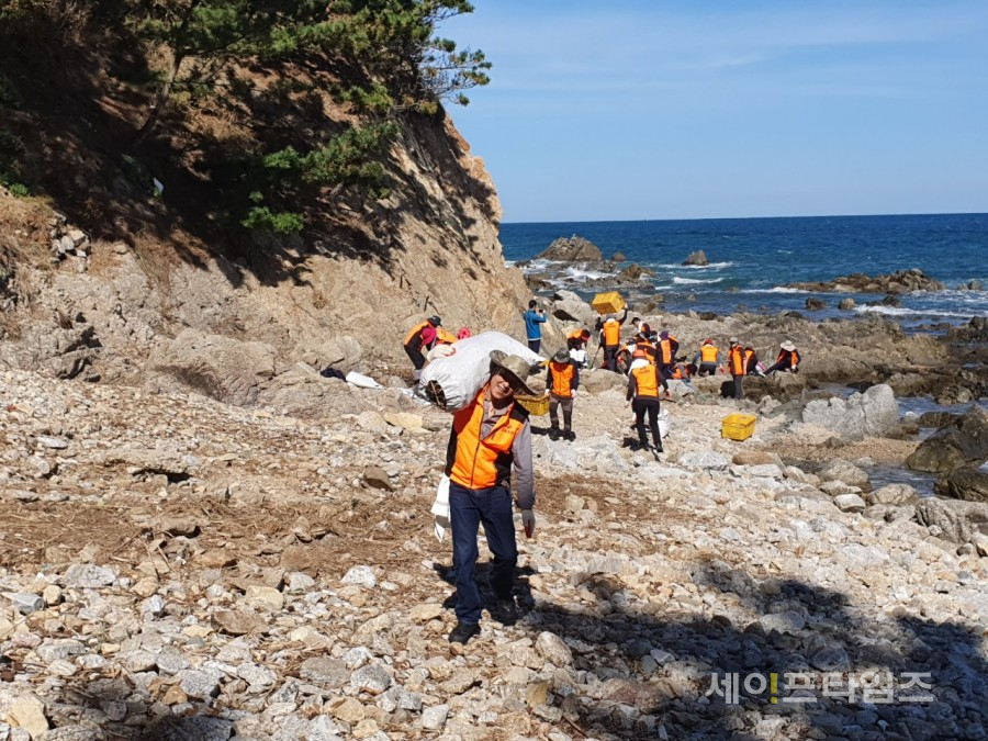 ▲ 봉사단이 9일 울진 주변 해안가에서 쓰레기를 치우고 있다. ⓒ 대전의용소방대 연합회