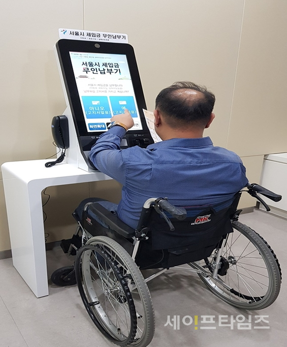 ▲ '장애인·어르신에 특화된 무인납부기'를 통해 휠체어 이용자가 세금을 납부하고 있다. ⓒ 서울시