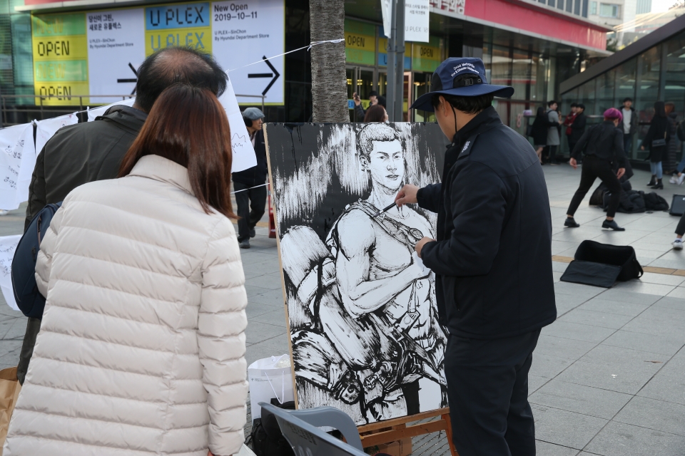▲ 김윤수 소방대원이 지난 16일 119런행사에서 그림 작업을 하고 있다. ⓒ 구로소방서