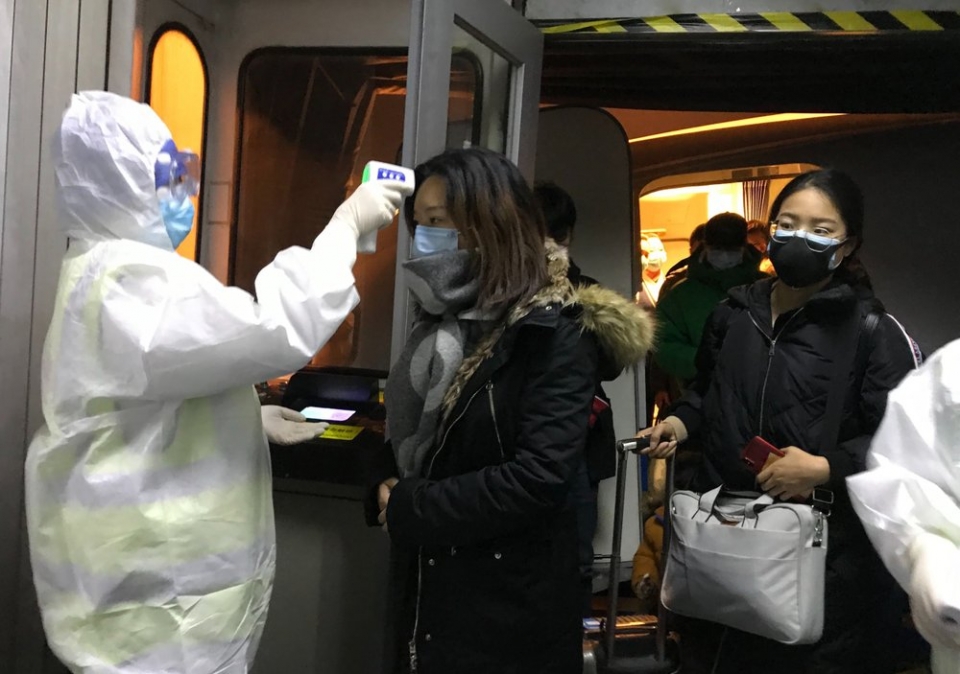 ▲ 중국 정부 관계자가 22일(현지시간) 우한시에서 출발해 베이징 공항에 도착한 승객들의 체온을 재고 있다. ⓒ AP 홈페이지