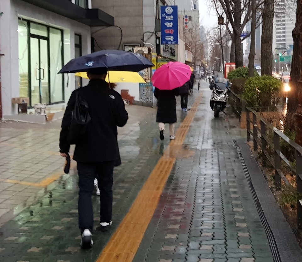 ▲ 삼각지역 인근 보도에서 시민들이 약한 비에 우산을 쓰고 걸어가고 있다 ⓒ 이상종기자