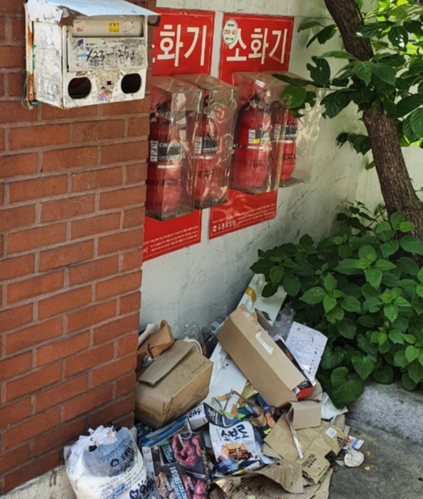 ▲ 서울 도봉구 쌍문동 주택가  비상소화기 아래 쓰레기가 쌓여있다. 한 주민은 "깨진 유리창의 법칙처럼 늘어가는 쓰레기에 비상시 소화기를 사용하지 못해 큰 사고가 날 수 있다"며 "쓰레기 투기를 하지 않는 시민의식과 행정당국의 조치가 필요하다"고 말했다. ⓒ 독자제공