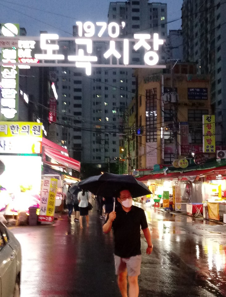 ▲ 한 시민이 강남구 도곡동시장에서 우산을 쓰고 걸어가고 있다. ⓒ 정석현 기자