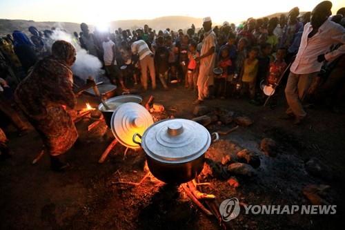 ▲ 티그라이 사태로 수단 접경지에 온 에티오피아 난민들이 23일 식사를 기다리고 있다.