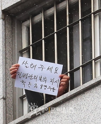 ▲ 서울동부구치소에서 수용자가 창 바깥으로 '살려주세요' 문구가 적힌 종이를 보여주고 있다. ⓒ 연합뉴스