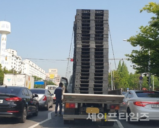 ▲ 팰릿을 과적한 화물차량 기사가 불안한 듯 슬링바를 점검하고 있다. ⓒ 세이프타임즈 DB