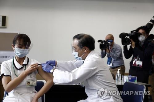 ▲ 일본이 신종 코로나바이러스 감염증 백신 접종을 시작한 지난달 17일 도쿄에서 한 의료종사 자(왼쪽)가 백신을 접종받고 있다.