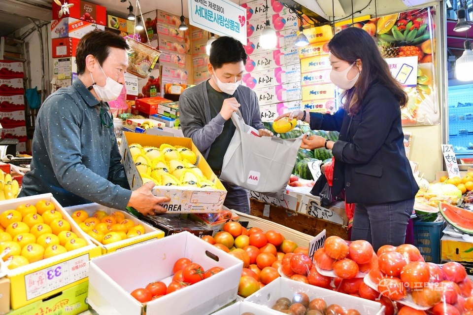 ▲ AIA생명 임직원 봉사단이 독립문 영천시장에서 과일을 구입하고 있다. ⓒ AIA생명