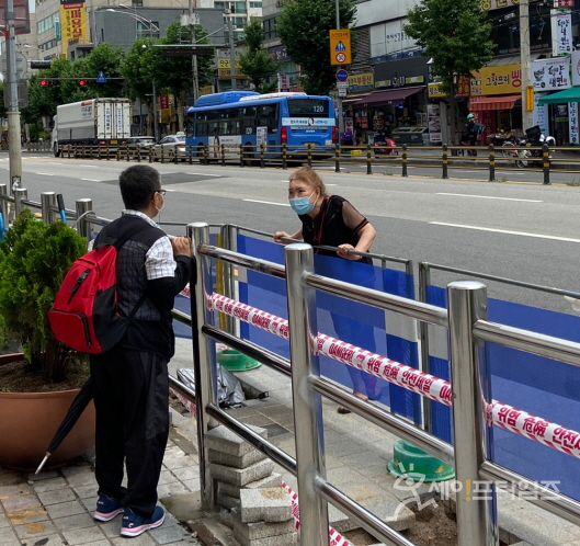 ▲ 5일 서울 동대문구 현대코아 앞에 시민이 울타리를 사이에 놓고 대화를 하고 있다. ⓒ 이찬우 기자