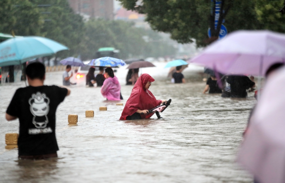▲ 중국 중부 허난성 성도인 정저우에 폭우가 쏟아지는 가운데 시민들이 물에 잠긴 거리를 걷고 있다. ⓒ 연합뉴스