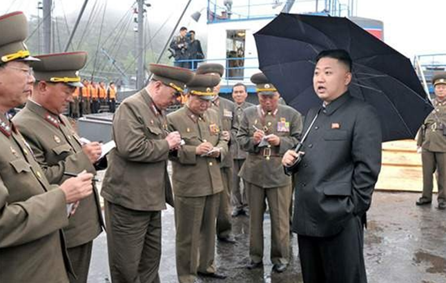 ▲ 김정은 북한 국무위원장이 직접 우산을 들고 군 간부를 지도하고 있다. ⓒ 연합뉴스