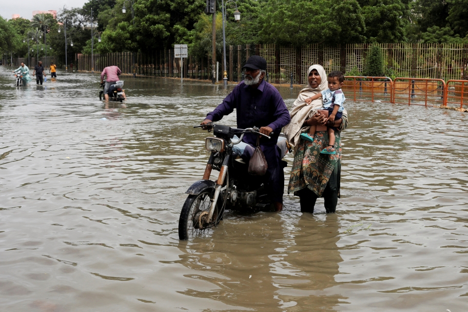 ▲ 폭우로 인해 도로가 물에 잠긴 파키스탄 카라치에서 한 가족이 길을 건너고 있다. ⓒ 연합뉴스