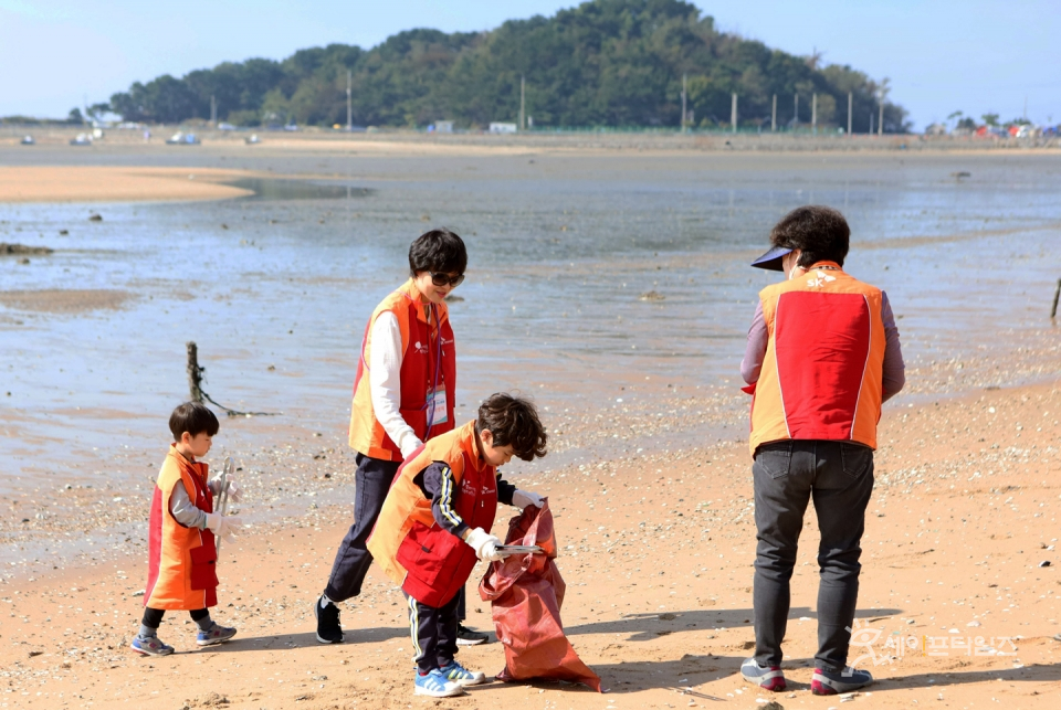 ▲ SK케미칼 관계사 임직원과 가족들이 인천 중구 을왕리 해변가에서 정화 봉사활동을 하고 있다. ⓒ SK케미칼