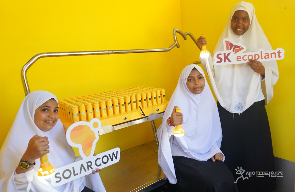 ▲ 탄자니아 학생들이 설치된 솔라밀크를 들고 웃고 있다. ⓒ SK에코플랜트
