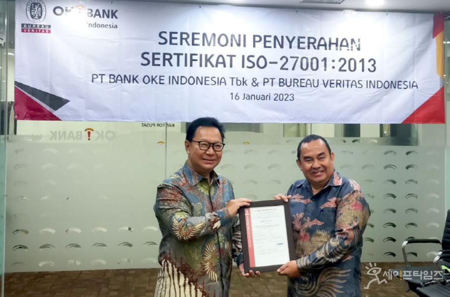 ▲ 헨드라 리에(Hendra Lie) OK뱅크 인도네시아 부행장(왼쪽)이 파자르 데니스와라(Fajar Deniswara) 뷰로 베리타스 인도네시아지부 인증사업부 관계자로부터 ISO 27001:2013 인증서를 받고 있다. ⓒ OK금융그룹