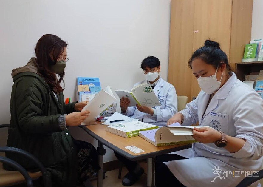 ▲ 고대안암병원 의료사회사업팀 관계자가 성북구 복지서비스 업무매뉴얼 책자를 살펴보고 있다. ⓒ 성북구