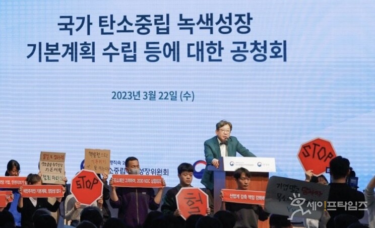 ▲ 환경단체가 김상협 위원장의 발언 중 기습 손팻말 시위를 하고 있다. ⓒ 김성진 기자