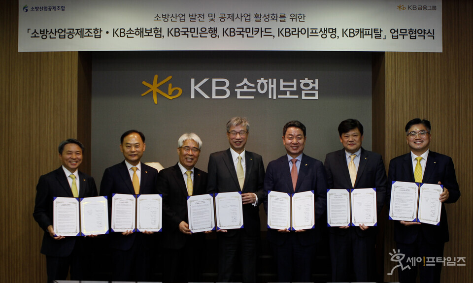 ▲ KB금융그룹 내 5개 계열사와 소방산업공제조합 관계자들이 소방산업 발전과 공제사업 활성화를 위한 업무 협약을 체결했다. 왼쪽부터 양원용 KB라이프생명 BA영업본부 부사장, 배정호 KB국민은행 SME마케팅본부장, 김기환 KB손해보험 대표이사, 허인 KB금융지주 부회장, 강희용 소방산업공제조합 이사장, 김인환 KB캐피탈 자동차금융본부 상무, 이정수 KB국민카드 기업·공공영업그룹 상무. ⓒ KB금융그룹