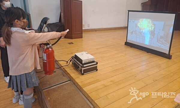 ▲ 서울 구로구의 한 초등학생이 가상현실 기기를 이용해 화재진압 실습을 하고 있다. ⓒ 구로구