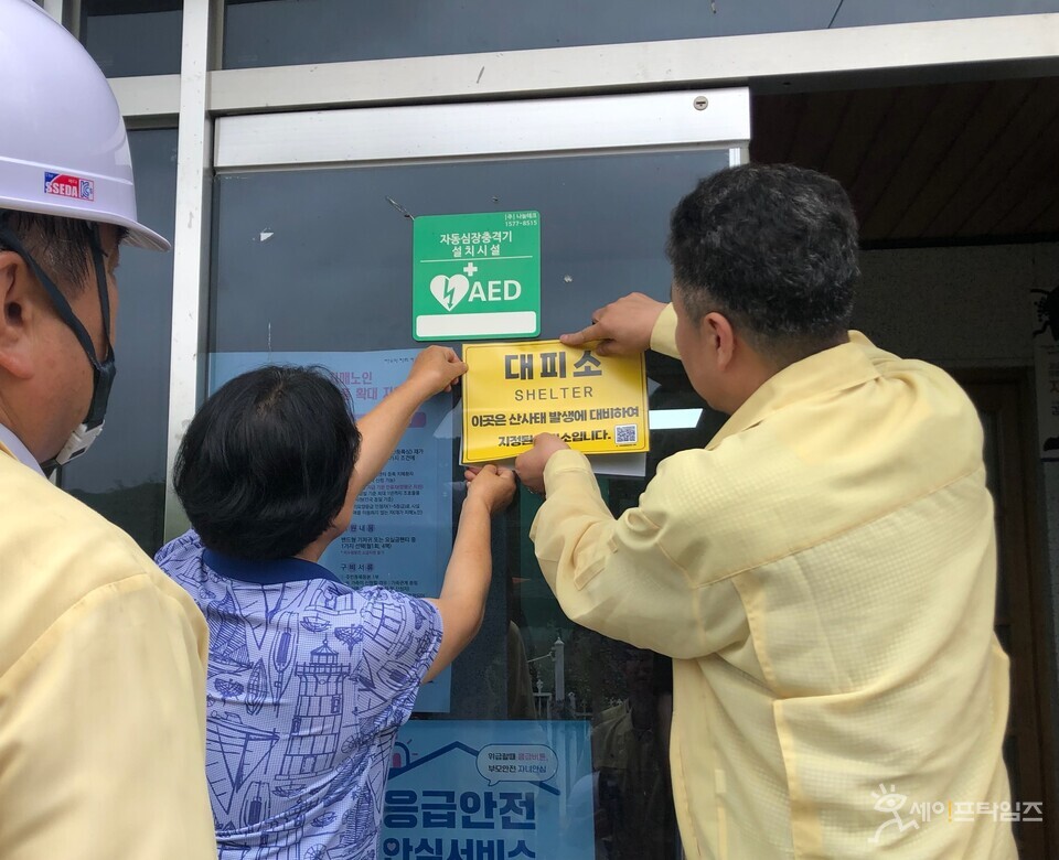 ▲ 산림청 관계자들이 경기도 양평군 대석1리 마을회관에서 산사태취약지역 대피소 표지판을 부착하고 있다. ⓒ 산림청