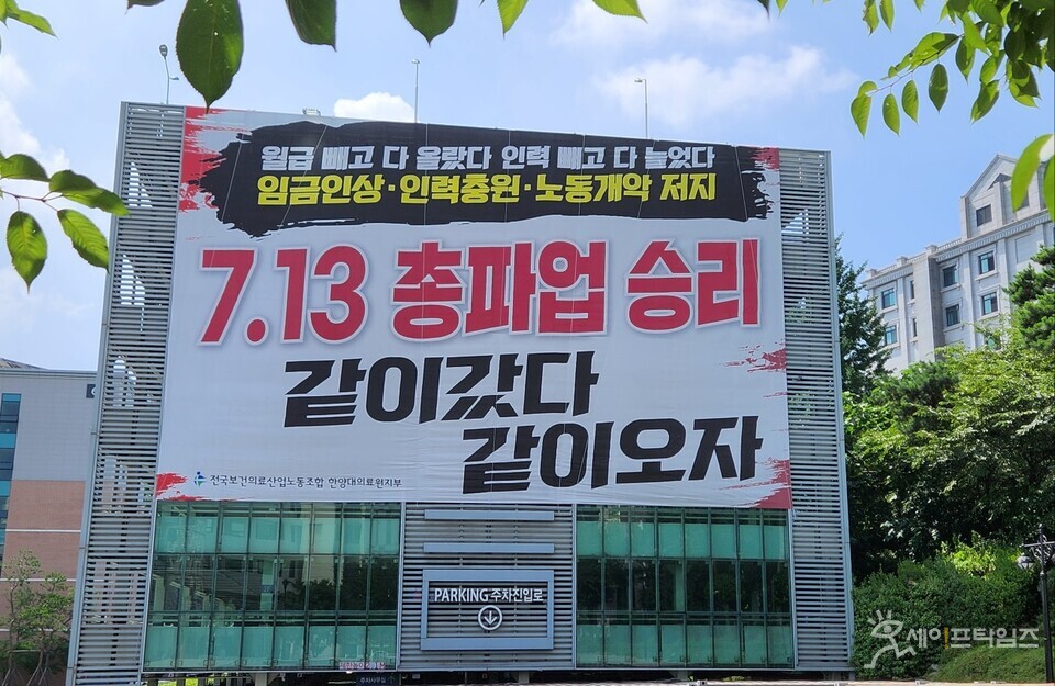 ▲ While nurses at Hanyang University Hospital are protesting against doctors' power abuse, the hospital's labor union has put up a placard announcing a general strike at the hospital's parking lot. ⓒ Reporter Kim Joo-heon