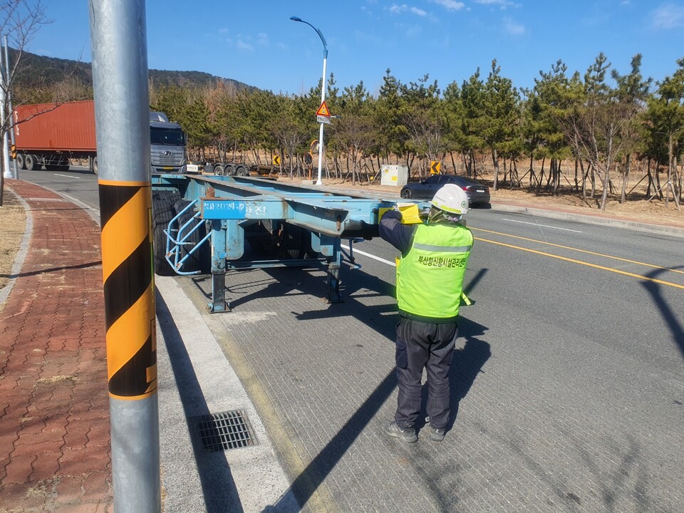▲ 부산항만공사(BPA) 관계자가 신항 배후도로 내 불법주정차 차량에 계도장을 부착하고 있다. ⓒ BPA