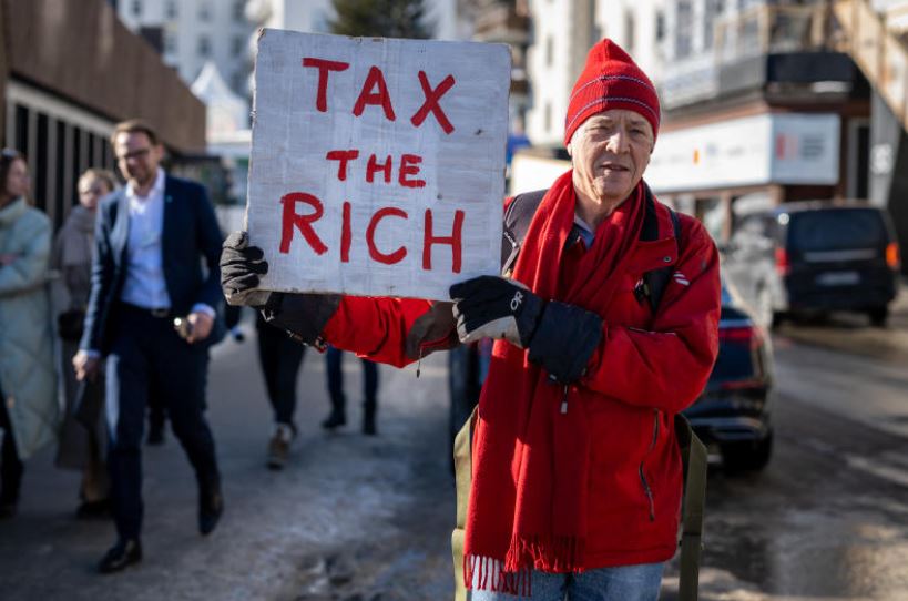 ▲ 지난 1월 영국의 백만장자 필 화이트가 스위스 다보스 포럼 행사장 앞에서 부자증세를 요구하는 시위를 하고 있다. ⓒ AFP 통신