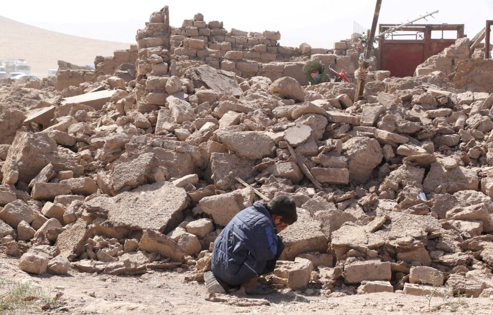 ▲ 지난 8일(현지시간) 아프가니스탄의 한 소년이 지진으로 폐허가 돼 버린 잔해 더미 옆에 앉아 울고 있다. ⓒ 로이터 통신