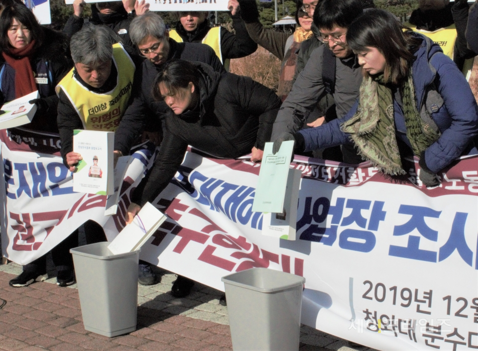 ▲ 김용균 1주기 추모위가 청와대 분수대 앞에서 기자회견문을 낭독한 뒤 조사보고서를 쓰레기통에 버리고 있다. ⓒ 세이프타임즈 DB