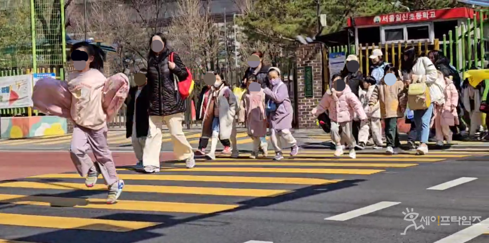 ▲ 서울 성북구 일신초의 학생들이 보호자들의 인솔 아래 차례대로 횡단보도를 건너고 있다. ⓒ 김주헌 기자