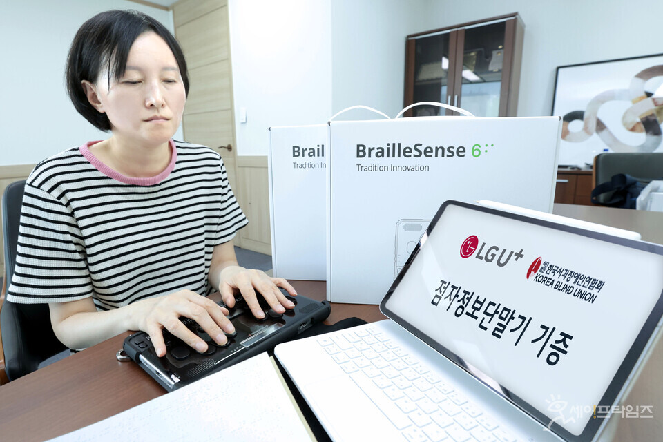 ▲  한국시각장애인연합회 관계자가 점자정보단말기를 살펴보고 있다. ⓒ LG유플러스