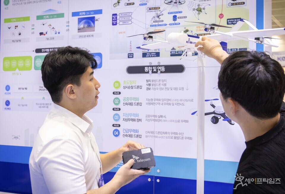 ▲ 무인이동체 산업엑스포 2024에서 SKT와 원자력연구소 관계자가 불법 드론 대응 체계에 대해 대화하고 있다. ⓒ SK텔레콤