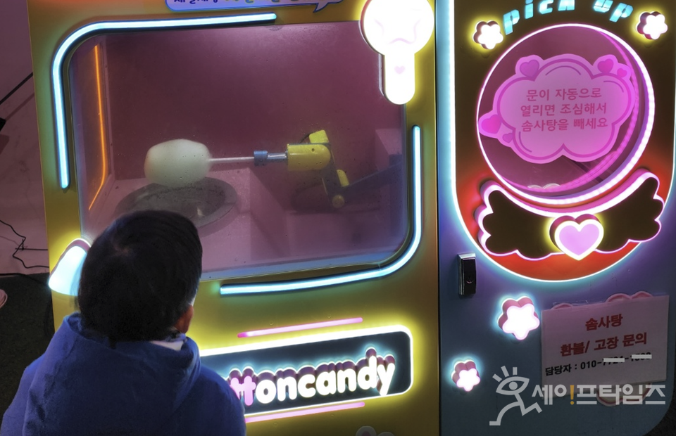 ▲ 한 어린아이가 솜사탕 자동판매기에서 솜사탕이 만들어지는 과정을 신기하게 바라보고 있다. ⓒ 세이프타임즈 김미영 기자