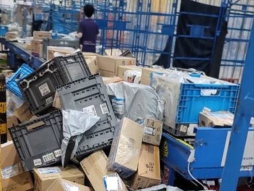 ▲ 사고 현장에 레일을 타고 내려온 물건을 제때 롤테이너에 담지 못해 택배물품들이 그대로 쌓여있다. ⓒ 택배노조