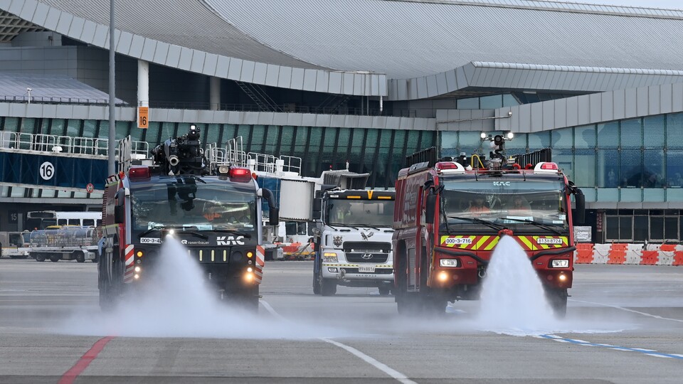 ▲ 한국공항공사 관계자들이 12일 김포공항 국내선 이동지역에서 살수 작업을 하고 있다. ⓒ 한국공항공사