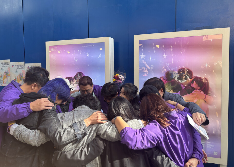 ▲ 10·29 이태원 참사 3주기를 엿새 앞둔 23일 이태원 참사가 일어났던 이태원역 1번 출구 인근에 전시된 추모 사진 전시 앞에서 유가족들이 서로를 껴안고 있다. ⓒ 연합뉴스